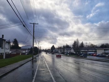 Cars on road in city against sky