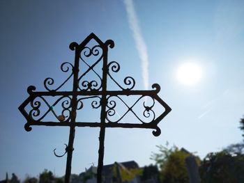 Low angle view of information sign against sky on sunny day