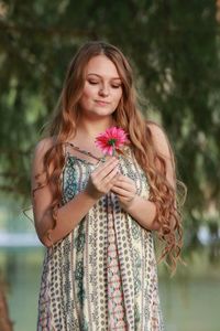 Smiling beautiful woman holding flower