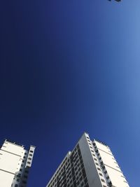 Low angle view of skyscrapers against clear blue sky