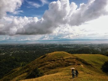 Scenic view of hills against storm clouds