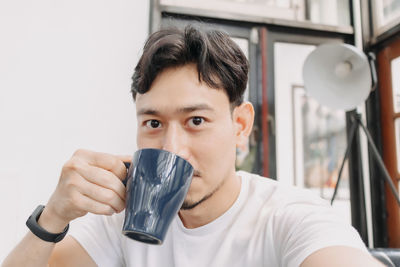 Portrait of young man holding camera