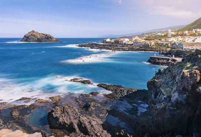 Panoramic view of sea and cityscape against sky