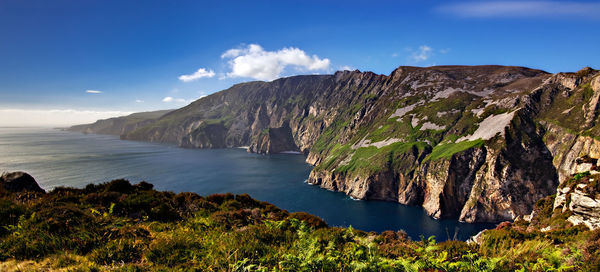 Scenic view of sea and mountains against sky