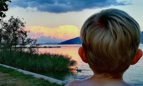 Rear view of girl at beach against sky