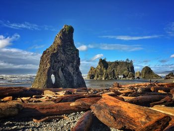 Rock formations on shore against blue sky