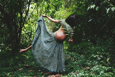 Rear view of boy playing in forest