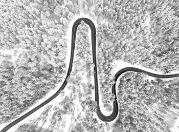 Aerial view of road amidst snow covered field