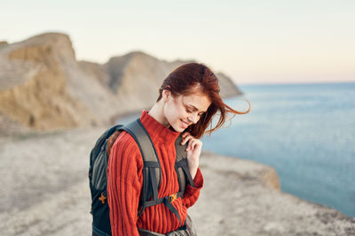 Woman standing at beach against sky