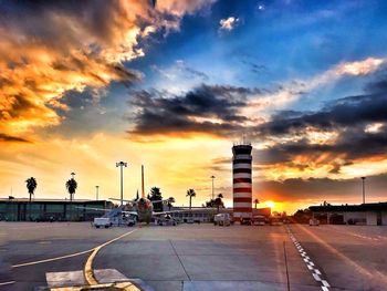 Airplane on airport runway against sky during sunset