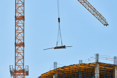 Low angle view of crane against clear sky