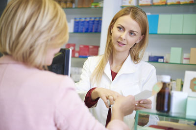 Portrait of pharmacist advising woman in pharmacy