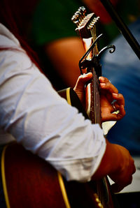 Midsection of man playing guitar