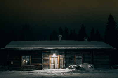 View of a dog against house at night