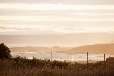 Scenic view of coast against sky during sunset