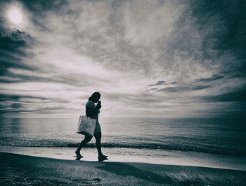 Full length of man standing on beach against sky