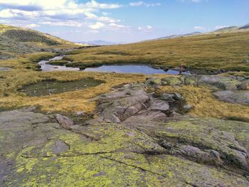 Scenic view of landscape with stream against sky