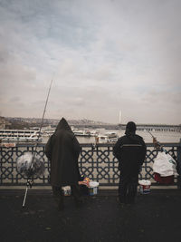 Rear view of people looking at sea against sky