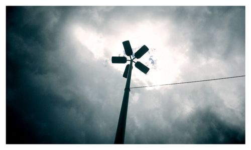 Low angle view of windmill against cloudy sky