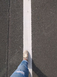 Low section of person standing on road