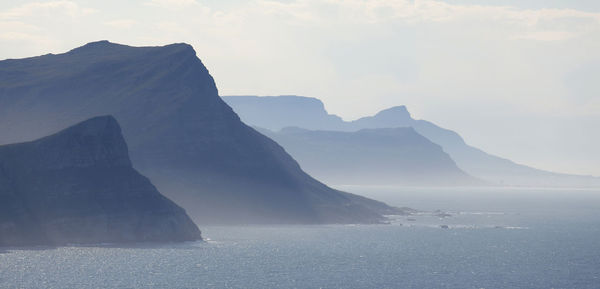 Scenic view of sea and mountains against sky