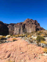 Rock formations on landscape against clear blue sky