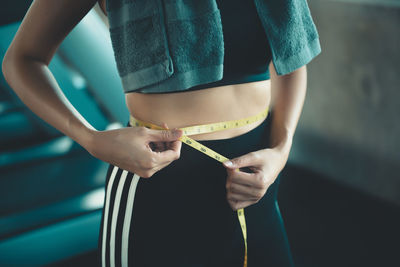 Midsection of woman holding umbrella standing