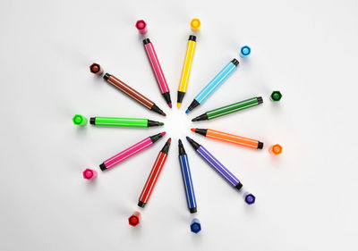 High angle view of multi colored pencils on white background