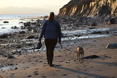 Rear view of dog walking on beach