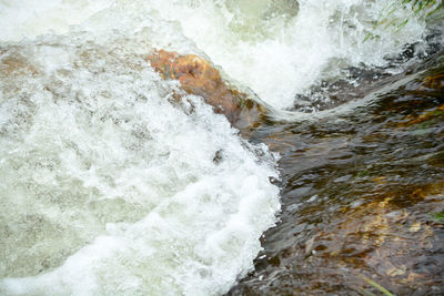 High angle view of waves splashing on rocks