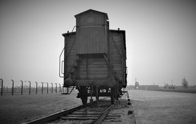 Locomotive on railroad track against clear sky