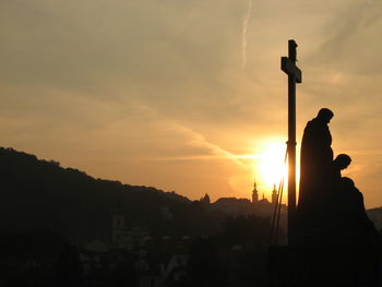 High section of silhouette mountain against orange sunset sky