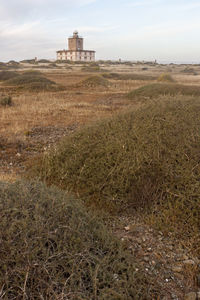 Built structure on field against sky