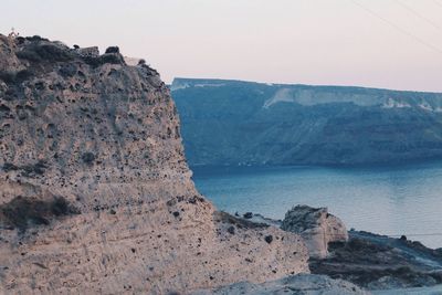 Rock formations by sea against sky