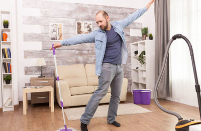 Young man standing on hardwood floor at home