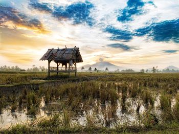 Gazebo on field against sky during sunset