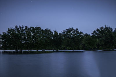 Scenic view of lake against clear blue sky at night