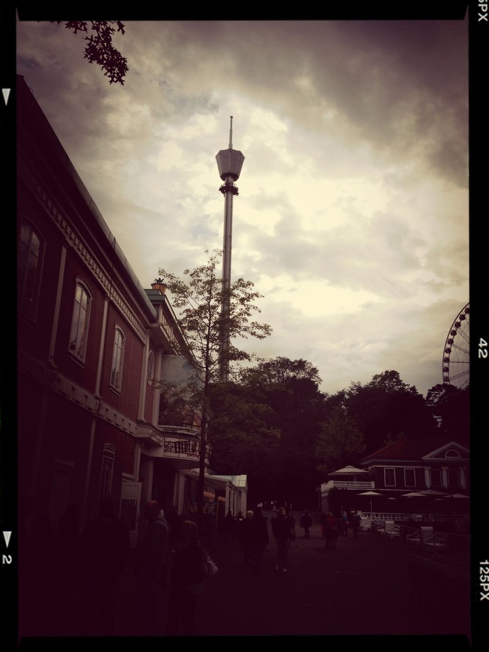 transfer print, building exterior, architecture, built structure, sky, auto post production filter, tree, cloud - sky, street light, city, cloud, cloudy, low angle view, silhouette, street, outdoors, dusk, building, day