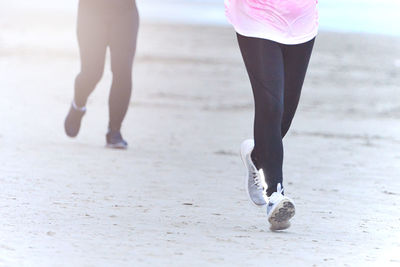 Low section of woman walking on beach