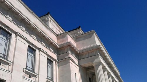 Low angle view of buildings against clear blue sky