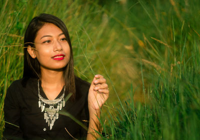 Young woman sitting amidst grass