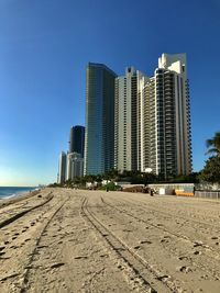 Modern buildings in city against clear blue sky