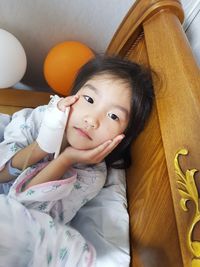 Portrait of cute girl with iv drip sitting at home