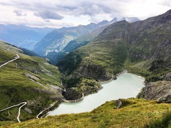 Scenic view of river amidst mountains against sky