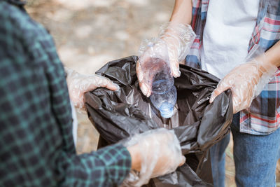 Midsection of man cleaning garbage