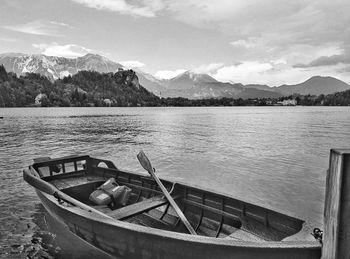 Boat moored on lake against sky