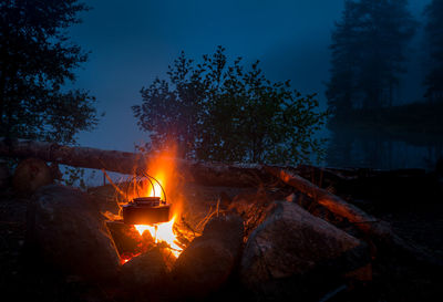 Bonfire on wooden structure against sky at night