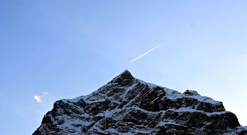 Low angle view of snowcapped mountain against sky