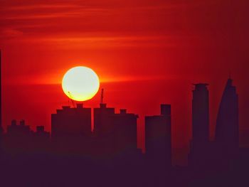 Silhouette buildings against sky during sunset