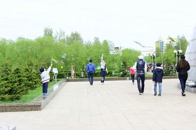 People walking on footpath against sky